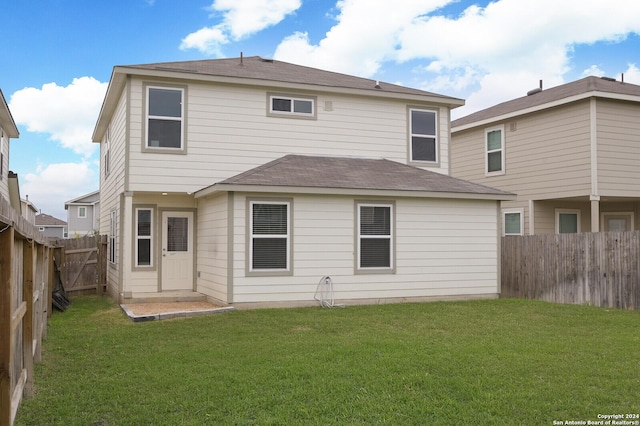 rear view of property with a yard