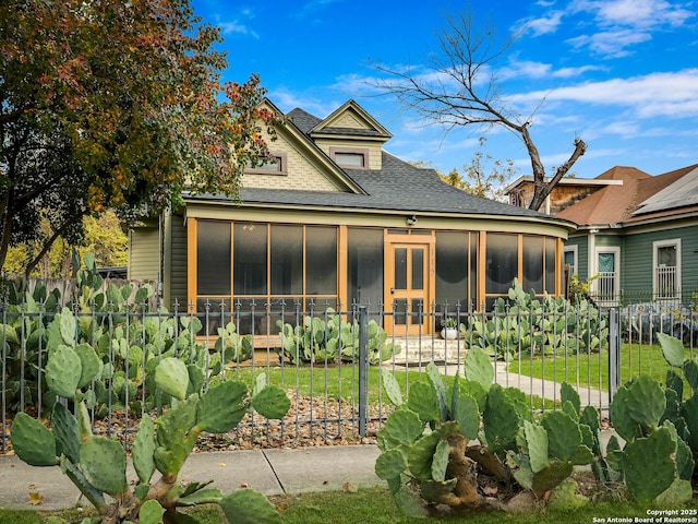 back of property with a sunroom