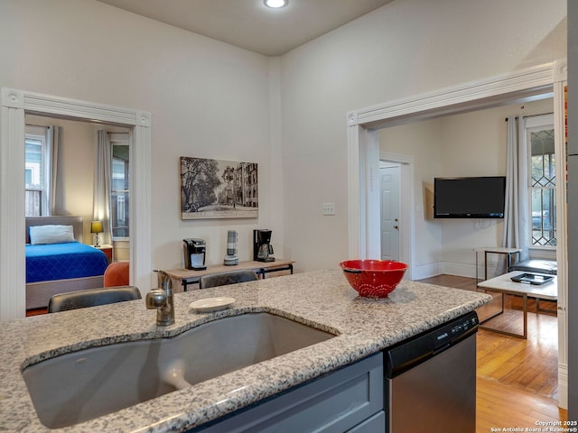 kitchen with dishwasher, light hardwood / wood-style flooring, plenty of natural light, and sink