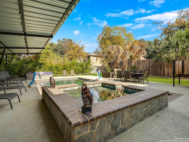 view of patio / terrace featuring a swimming pool with hot tub