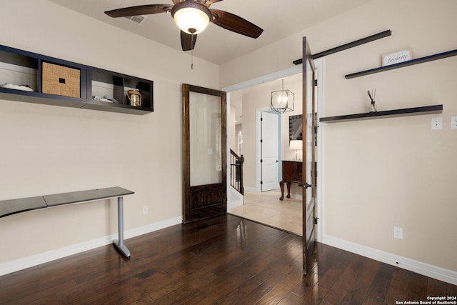 interior space with wood-type flooring and ceiling fan with notable chandelier