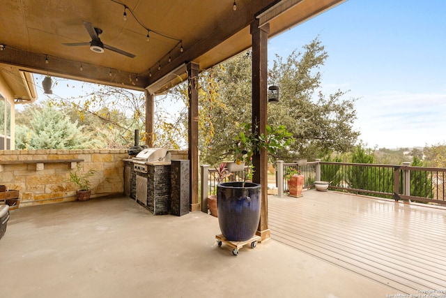 view of patio / terrace with a wooden deck, ceiling fan, area for grilling, and exterior kitchen