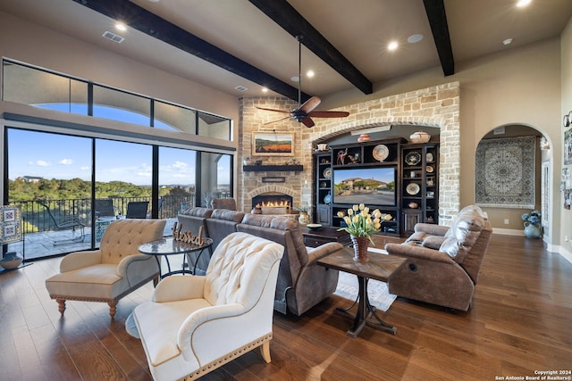 living room featuring dark wood-type flooring, ceiling fan, and a stone fireplace