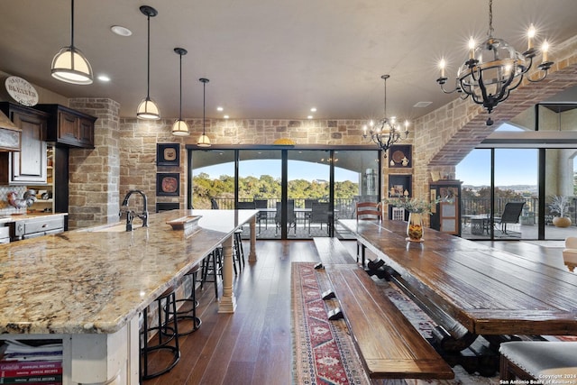 dining room with an inviting chandelier, dark hardwood / wood-style floors, sink, and a wealth of natural light