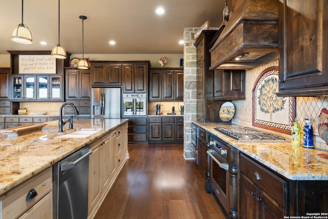 kitchen featuring sink, backsplash, custom exhaust hood, and appliances with stainless steel finishes