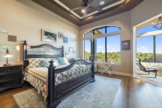 bedroom with crown molding, a towering ceiling, ceiling fan with notable chandelier, and dark wood-type flooring