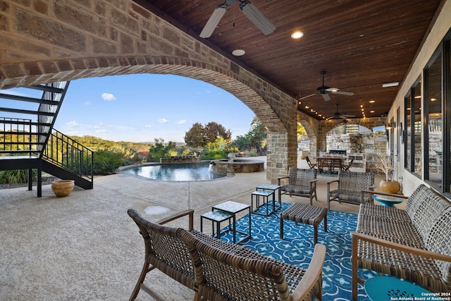 view of patio with an outdoor living space, ceiling fan, and a pool with hot tub