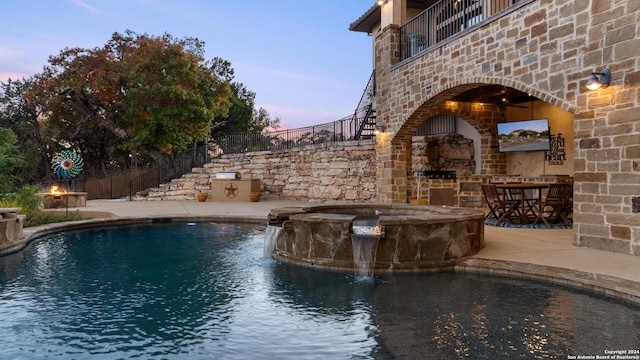 view of pool with pool water feature, exterior fireplace, an in ground hot tub, and a patio area