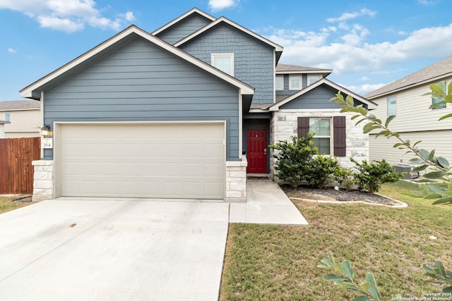 craftsman inspired home with a garage and a front yard