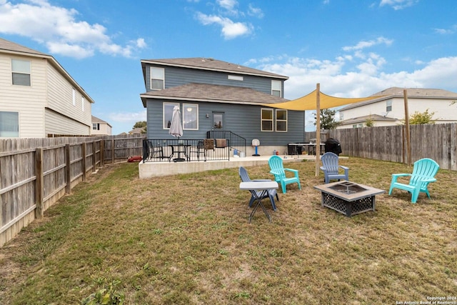 back of property featuring a lawn, a patio, and a fire pit