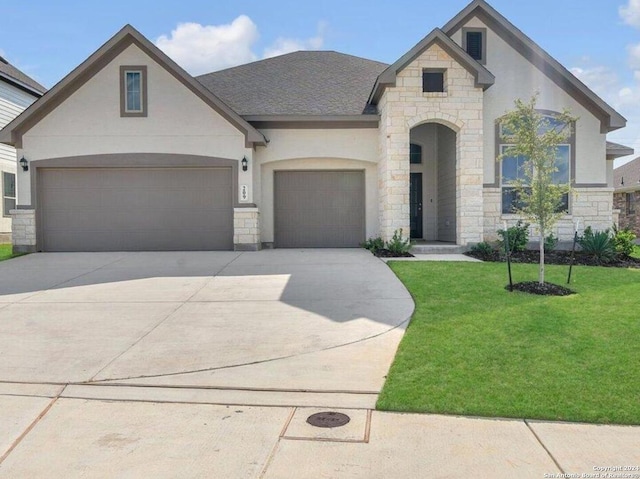 french country home featuring a garage and a front lawn