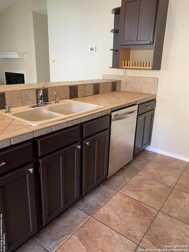 kitchen with tile counters, dishwasher, sink, and dark brown cabinets