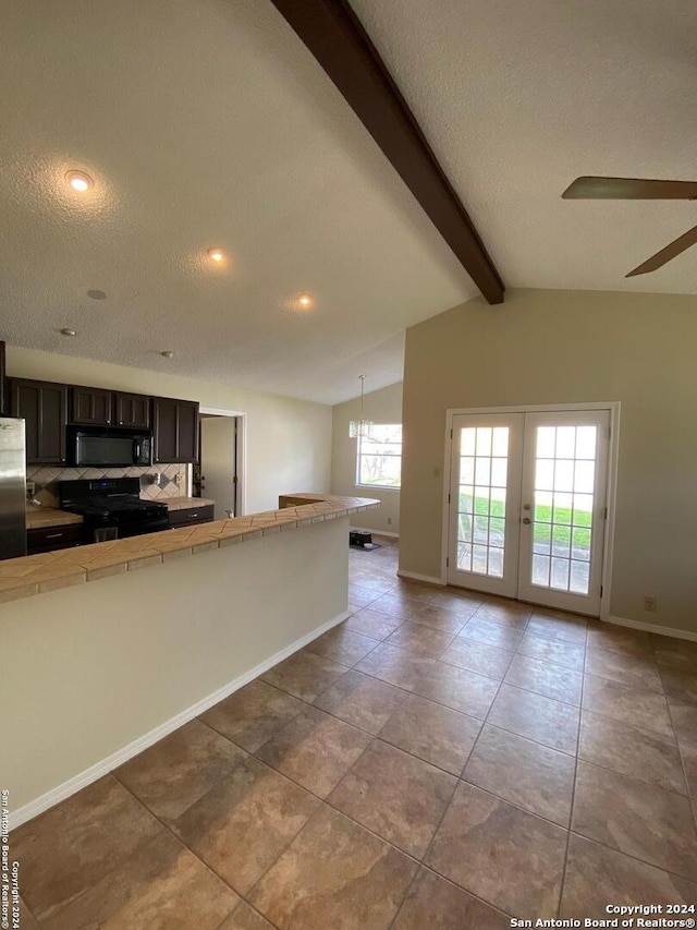 kitchen featuring tile counters, dark brown cabinets, vaulted ceiling with beams, a textured ceiling, and black appliances