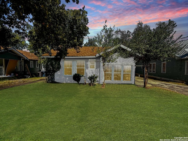 back house at dusk with a yard