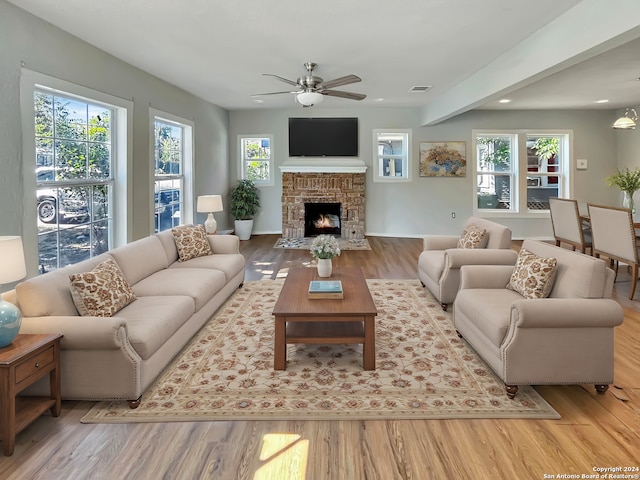 living room featuring ceiling fan, plenty of natural light, and light hardwood / wood-style floors