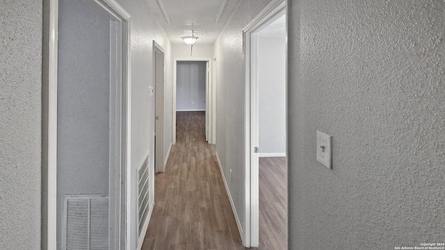 corridor featuring hardwood / wood-style floors and a textured ceiling