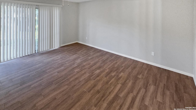 unfurnished room with dark wood-type flooring