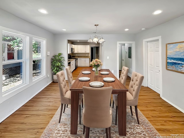 dining room featuring light hardwood / wood-style flooring and a notable chandelier