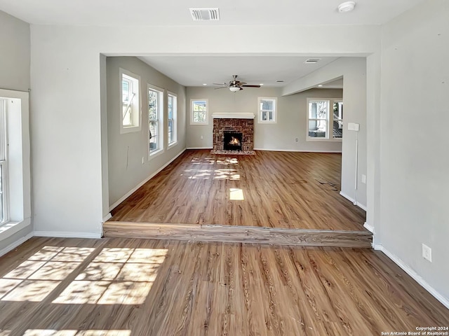 unfurnished living room with ceiling fan and wood-type flooring