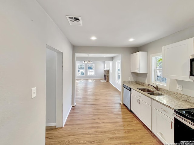 kitchen with white cabinets, light hardwood / wood-style floors, sink, and stainless steel appliances