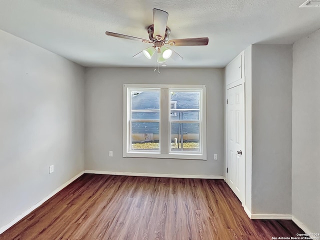 unfurnished room featuring a textured ceiling, ceiling fan, and dark wood-type flooring