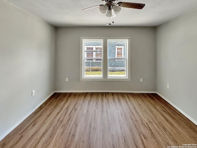 unfurnished room featuring ceiling fan, light hardwood / wood-style floors, and a textured ceiling