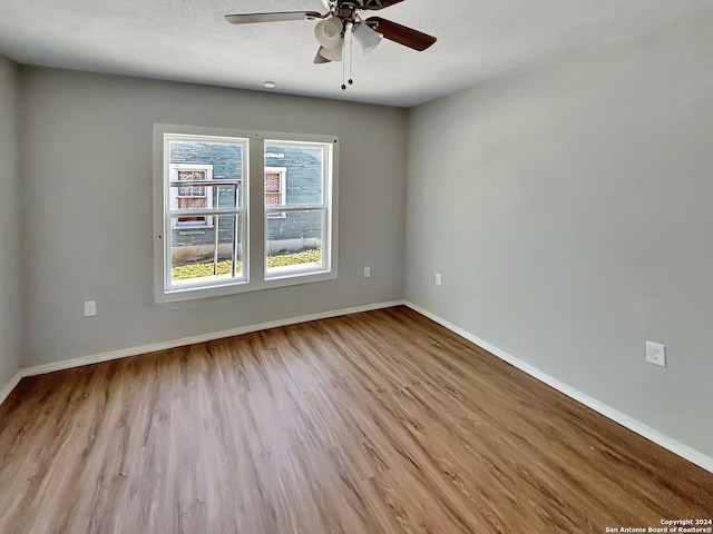 unfurnished room featuring ceiling fan, light hardwood / wood-style flooring, and a textured ceiling