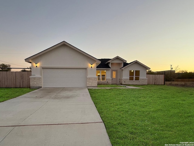 ranch-style house featuring a yard and a garage