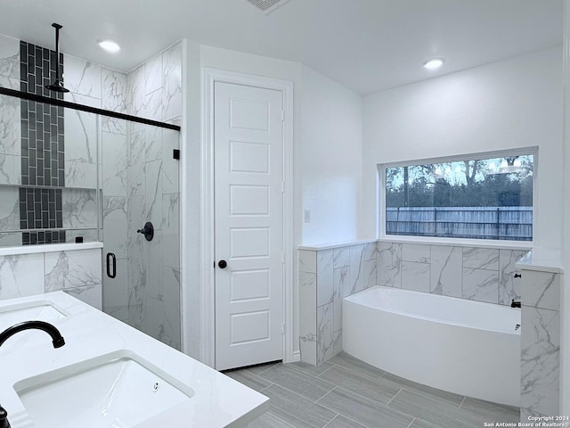 bathroom featuring vanity, tile walls, and plus walk in shower