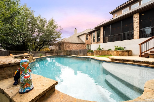 pool at dusk with a sunroom