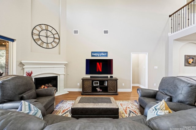 living room with wood-type flooring and a towering ceiling