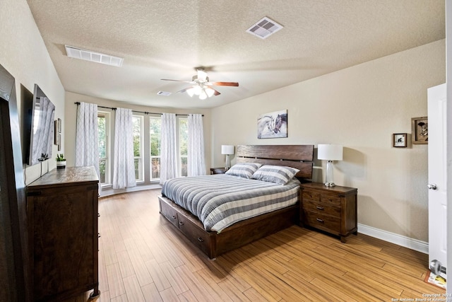 bedroom featuring ceiling fan, a textured ceiling, and light hardwood / wood-style flooring