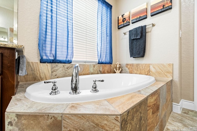 bathroom featuring tiled bath and vanity