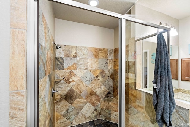 bathroom with a shower with door and a textured ceiling