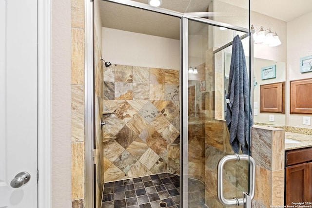 bathroom with a shower with door and vanity