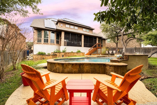 pool at dusk with a sunroom