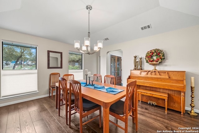 dining space with a chandelier, dark wood-type flooring, and lofted ceiling