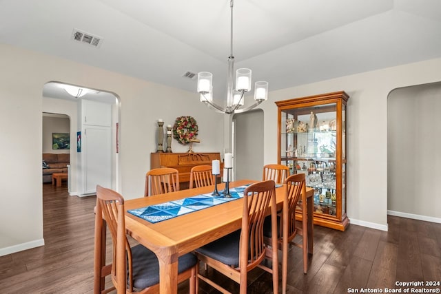 dining space with dark wood-type flooring and a notable chandelier