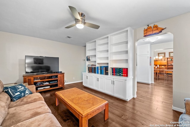 living room with ceiling fan and dark wood-type flooring