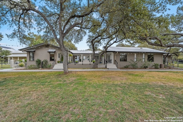 ranch-style house featuring a porch, a front yard, and central AC