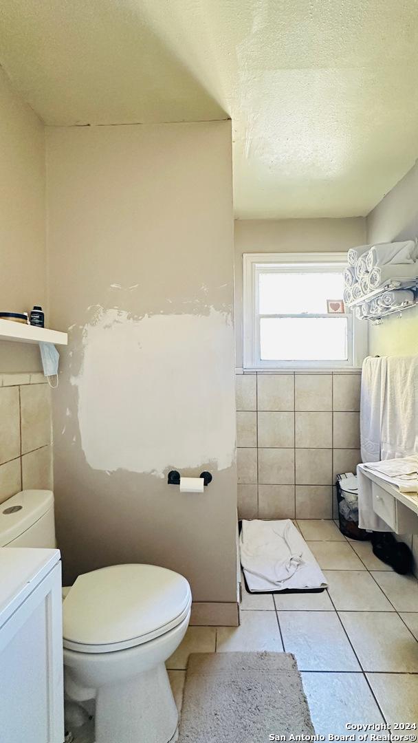 bathroom with tile patterned floors, vanity, and tile walls