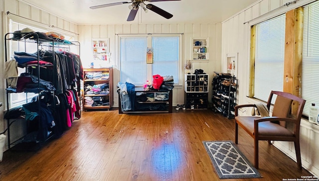 interior space with built in shelves, hardwood / wood-style flooring, and ceiling fan