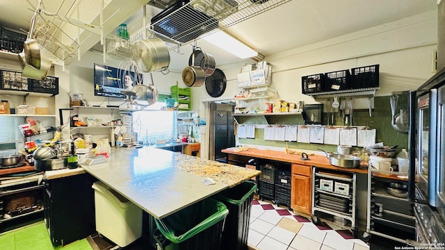 kitchen with kitchen peninsula and light tile patterned floors