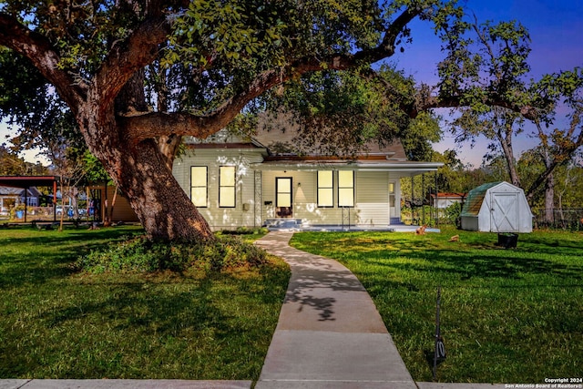 view of front of house with a yard and a shed