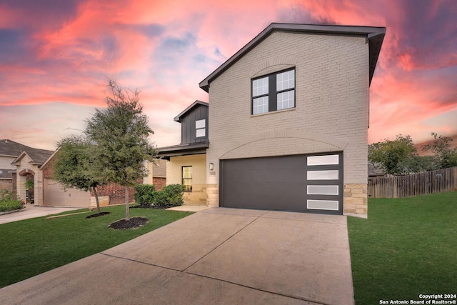 view of front of home with a garage and a lawn