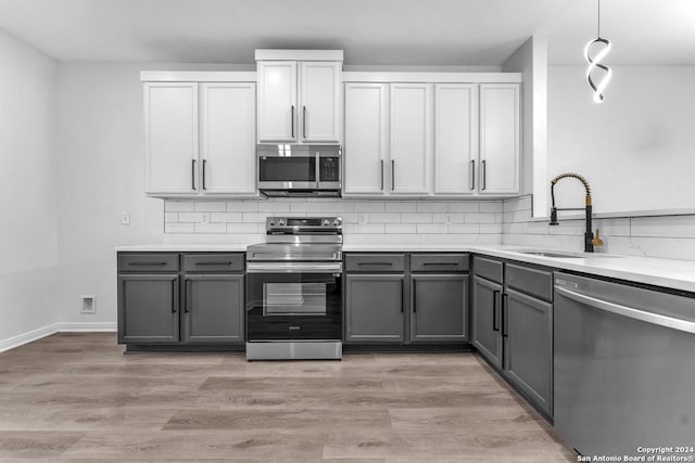 kitchen featuring stainless steel appliances, gray cabinets, tasteful backsplash, and sink