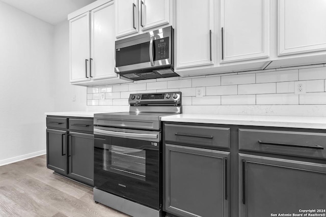 kitchen with white cabinetry, stainless steel appliances, light hardwood / wood-style flooring, gray cabinets, and decorative backsplash