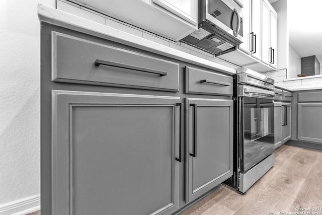 kitchen with gray cabinetry and light hardwood / wood-style flooring