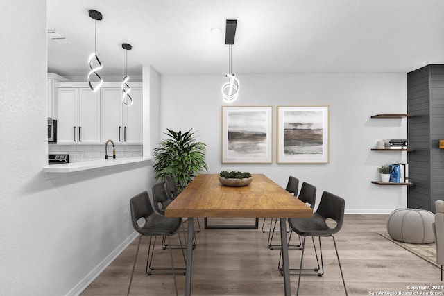 dining space featuring hardwood / wood-style floors and sink