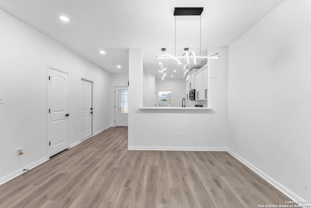 unfurnished dining area with light wood-type flooring and sink